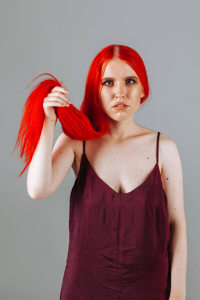 Girl touches her red long hair - Foto, Imagen