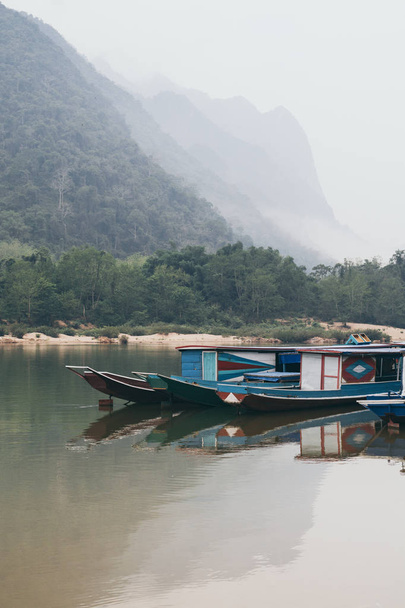 Tradizionale barca lenta in legno laotiano sul fiume Nam Ou vicino al villaggio di Nong Khiaw, Laos
 - Foto, immagini