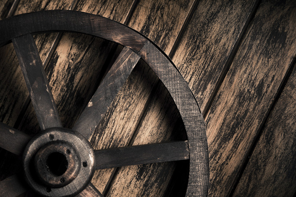 Old wheel on a wooden background - Fotoğraf, Görsel