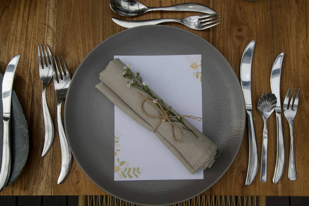 Restaurant concept. Bruiloft of feestelijke tafel setting. Keramische plaat en bestek met menu. Mooi en eenvoudig arrangement. - Foto, afbeelding