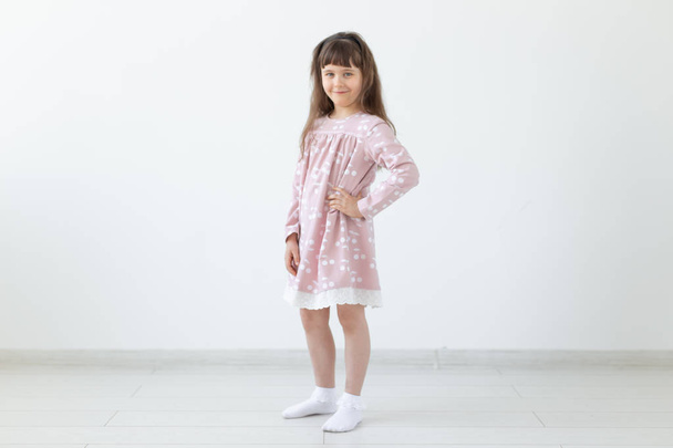 model, giyim tasarımcısı, insan kavramı - beyaz arka plan üzerinde pembe elbise küçük kız modeli - Fotoğraf, Görsel