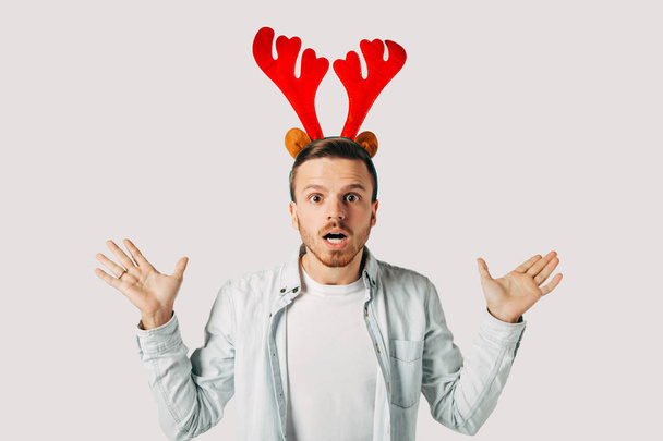 surprised man in red christmas hat over grey background - Foto, immagini