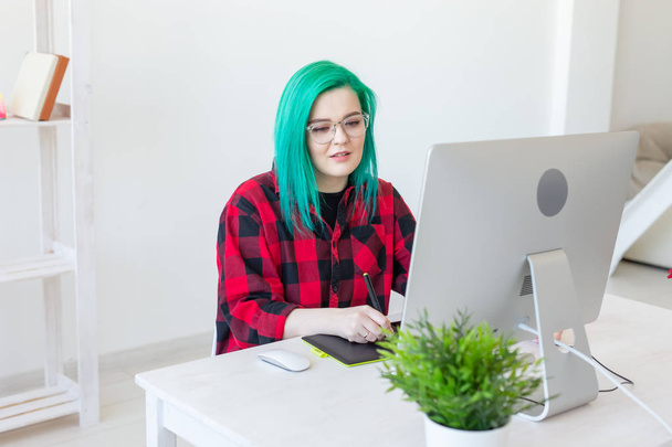 Concept de designer, illustrateur, artiste et personne portrait d'une jeune femme contemporaine aux cheveux verts à l'aide d'un ordinateur portable et d'une tablette graphique tout en travaillant
 - Photo, image
