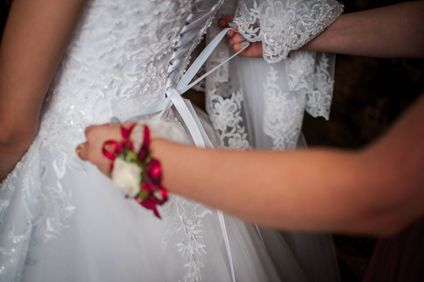 Las damas de honor ayudan a la novia a usar vestido de novia
 - Foto, imagen