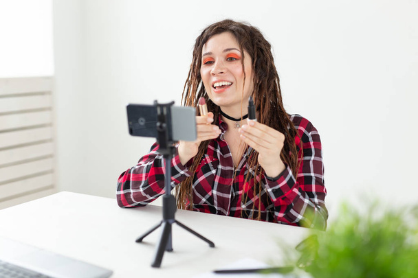 Blogging, vlog and cosmetic concept - young woman blogger talking on the camera about black lipstick - Fotoğraf, Görsel