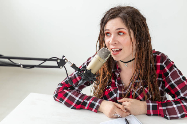 Blogger, radio host and people concept - Expressive modern DJ girl with dreadlocks working at the radio - Фото, зображення