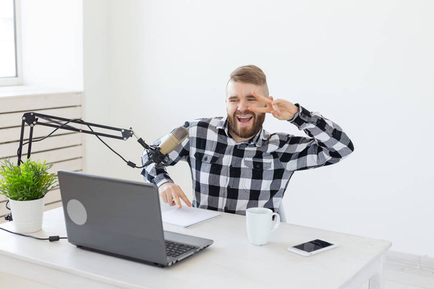 Radyo sunucusu, streamer ve blogger kavramı - Yakışıklı adam radyo istasyonunda radyo sunucusu olarak çalışan mikrofon önünde oturan - Fotoğraf, Görsel