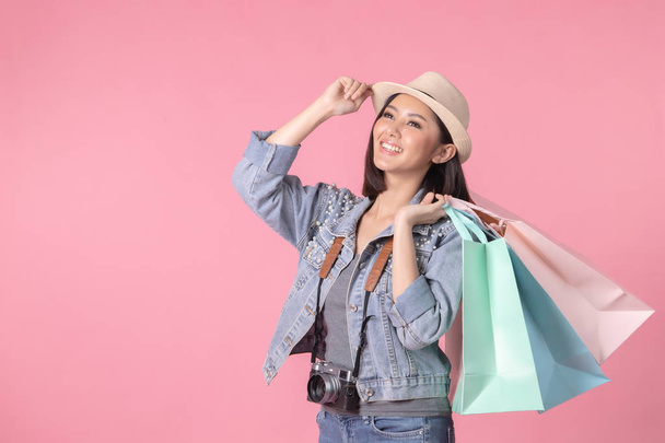 Tourist woman in summer casual clothes.Asian Smiling woman .Passenger traveling abroad to travel on pink background.Asian woman going to summer vacation.Travel trip funny. - Photo, Image