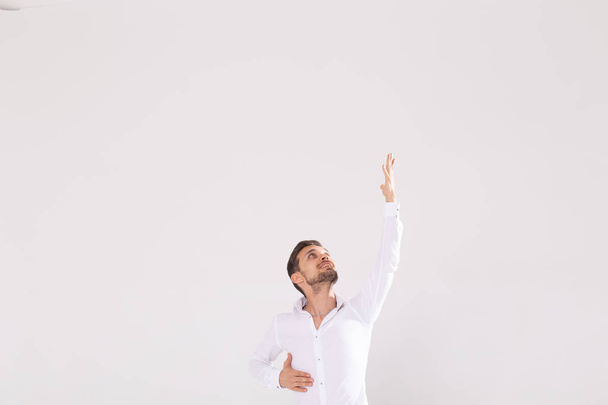 Handsome man with beard pointing in one direction on a white background, copyspace - Foto, imagen