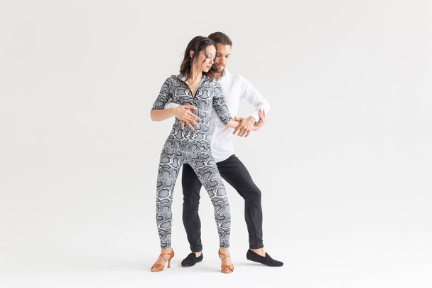 Passionate couple dancing social danse kizomba or bachata or semba or taraxia on white background with copy space - Zdjęcie, obraz