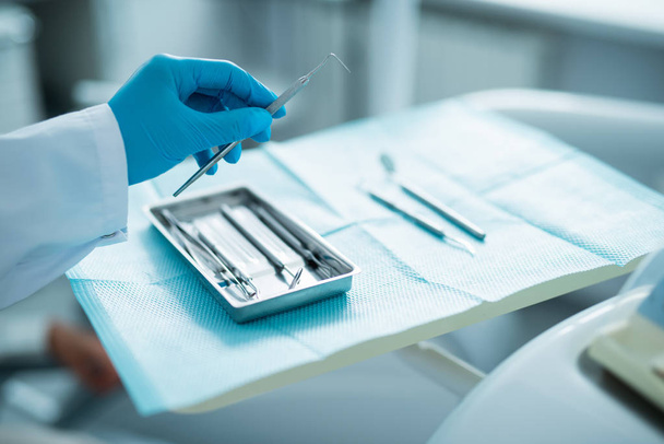 Zubař pracující s chirurgickými nástroji v kanceláři - Fotografie, Obrázek