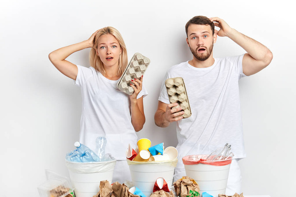 close up portrait of puzzled woman and man holding carton egg pack - Photo, image