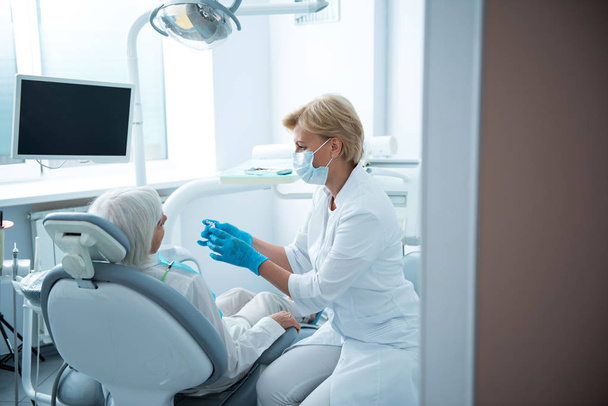 Professional stomatologist checking teeth of adult lady - Photo, Image