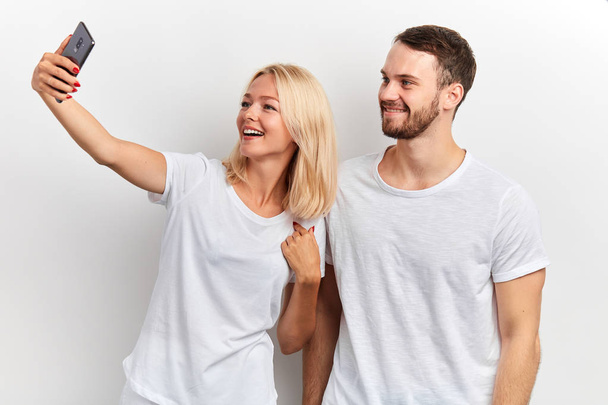 happy attractive couple take selfie on phone isolated on white background - Fotoğraf, Görsel