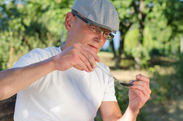 εθισμένος άνθρωπος πλήρωση μια σύριγγα με διαλυτό ηρωίνη - Φωτογραφία, εικόνα