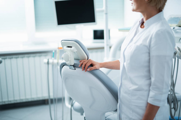 Female doctor is standing near dental chair - Fotoğraf, Görsel