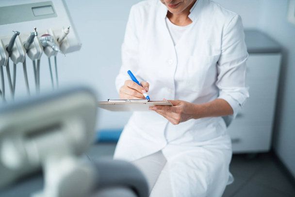 Female doctor is writing data to the questionnaire - Photo, image