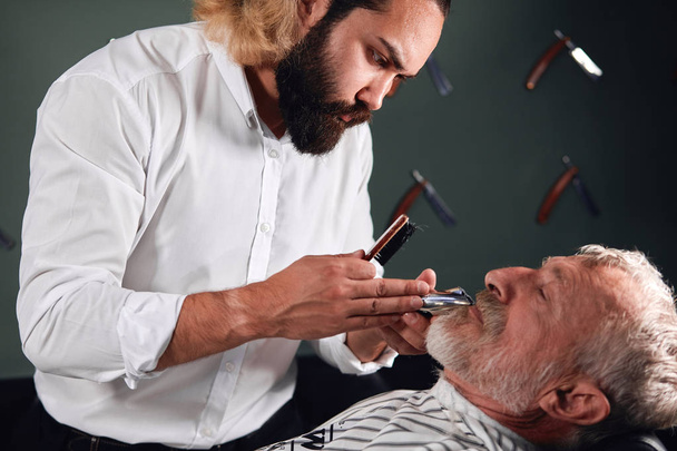 handsome stylist makes hairstyle for old man - Zdjęcie, obraz