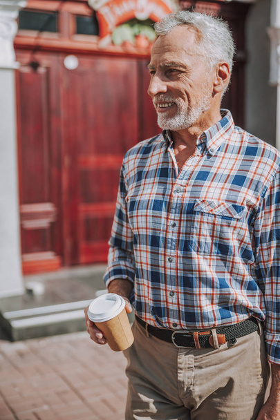 Smiling mature man with coffee to go stock photo - Foto, imagen