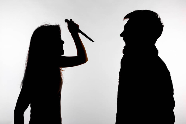 Aggressions- und Missbrauchskonzept - Mann und Frau drücken häusliche Gewalt in Studiosilhouette isoliert auf weißem Hintergrund aus. - Foto, Bild