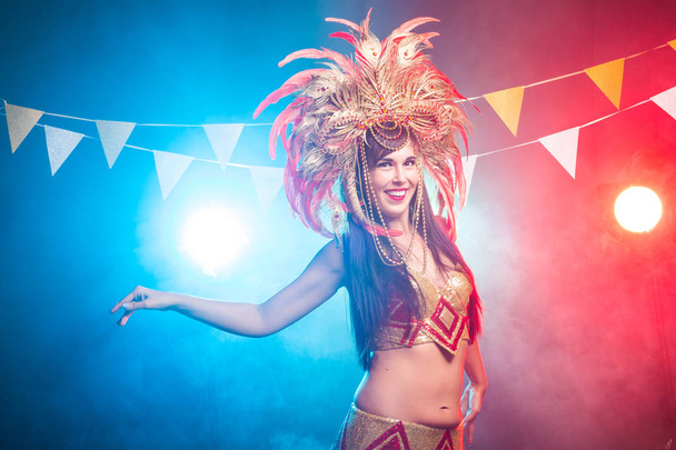 Karnevaali, vatsa tanssi ja loma käsite Kaunis naispuolinen samba tanssija yllään kulta puku ja hymyilevä
 - Valokuva, kuva