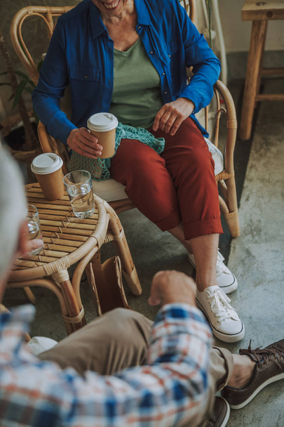 Couple in cane chairs drinking coffee stock photo - Фото, изображение