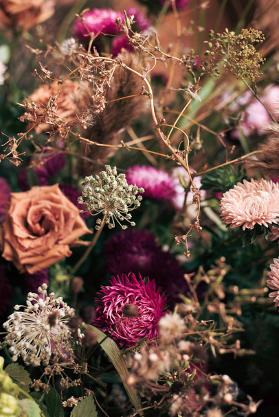 a bouquet of dried flowers, roses and dry field grass. Beautiful vertical autumn background - Фото, зображення