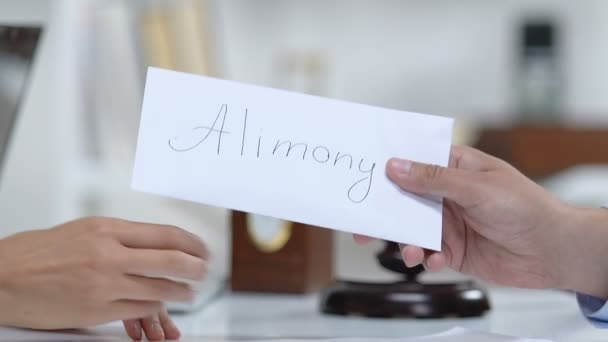Male giving ex-wife envelope with dollar banknotes, alimony payment, divorce - Metraje, vídeo