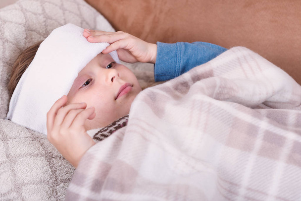 Хвора дівчина з шарфом лежить на ліжку
 - Фото, зображення