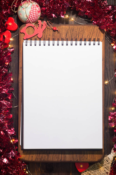 Bloc de notas en blanco en la tabla de cortar. Ambiente navideño
 - Foto, Imagen