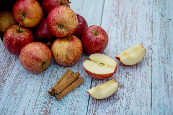 有機熟したリンゴとシナモンは、木製のテーブルの上に固執します。新鮮な切りんご。食材を調理する。収穫. - 写真・画像