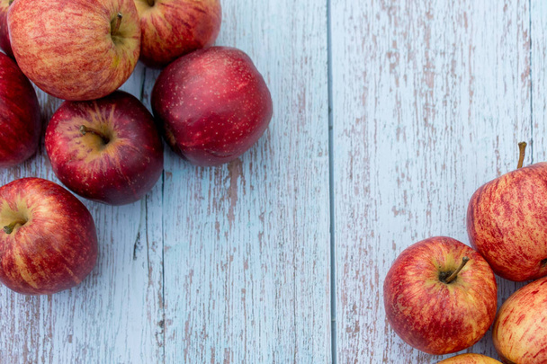 Organiczne czerwone dojrzałe jabłka na drewnianym stole w ogrodzie. Składniki do gotowania. Zbiorów. Puste miejsce na wprowadzanie tekstu - Zdjęcie, obraz