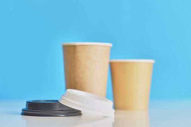 Две бумажные чашки кофе на синем фоне. Кофе для влюбленных
 - Фото, изображение