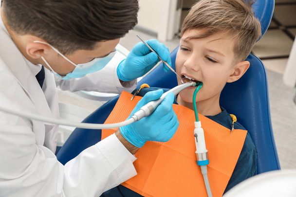 Professional dentist working with little boy in clinic - 写真・画像