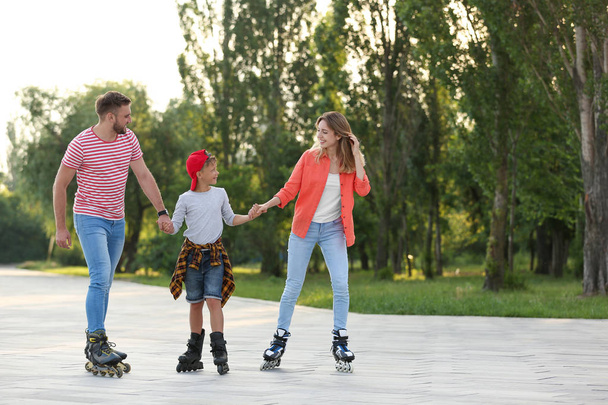 Happy family roller skating on city street. Space for text - Foto, imagen