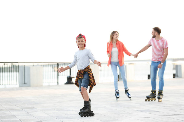 Happy family roller skating on city street - Φωτογραφία, εικόνα