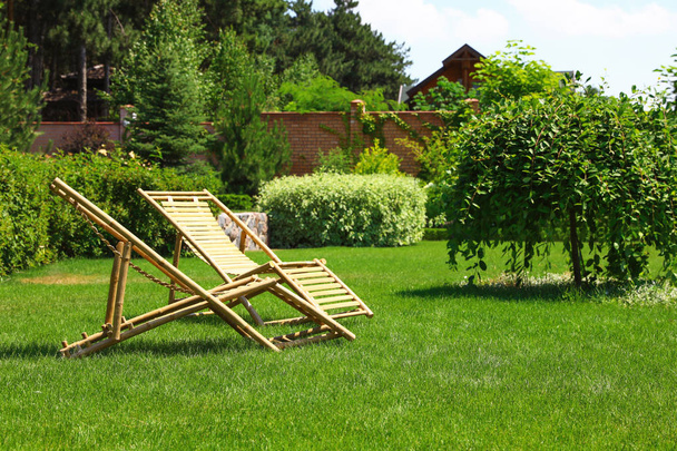 Wooden deck chairs in garden on sunny day - Foto, imagen