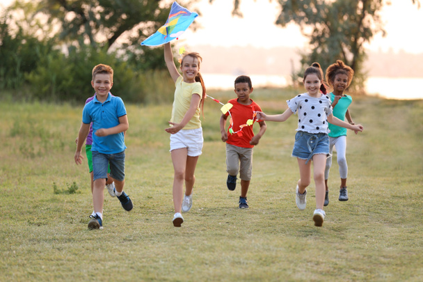 Lindos niños pequeños jugando con cometa al aire libre
 - Foto, Imagen