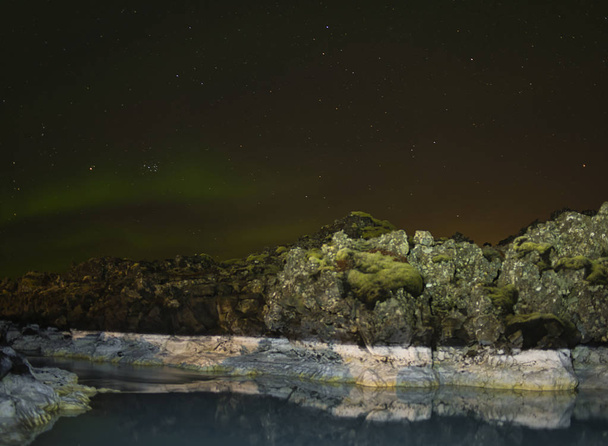 Északi fények és fényvisszaverő sziklák a vízben - Fotó, kép
