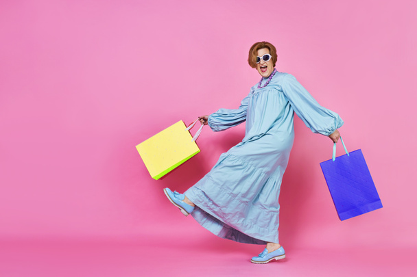 Funky oudere vrouw met aankopen, Shopaholic vrouw, kocht kleren, - Foto, afbeelding