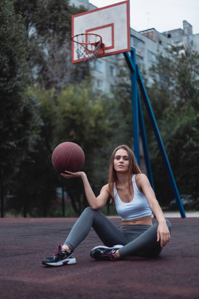 Basketbol sahasında topla bir kız. Tozluk ve üst giymiş spor giyim. - Fotoğraf, Görsel