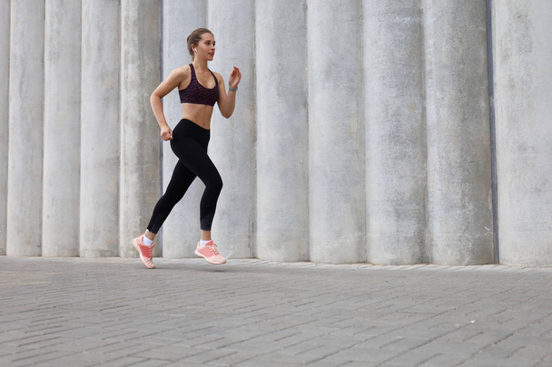Pleine longueur de jeune femme sportive faisant du jogging en faisant de l'exercice en plein air
 - Photo, image
