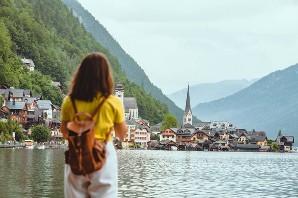 woman standing on the beach looking at hallstatt city - Photo, Image