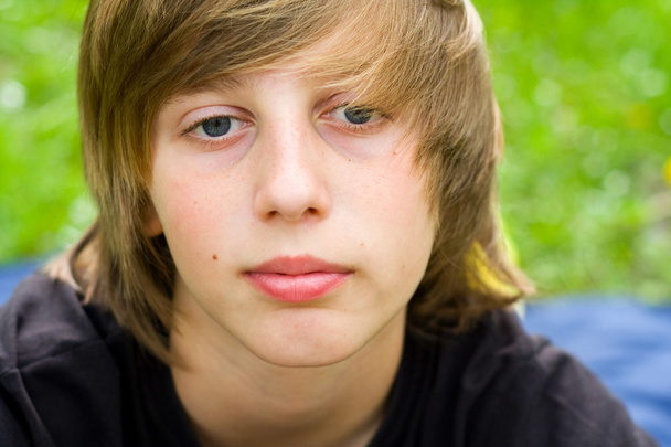 Ευρωπαϊκό σχολικής ηλικίας αγόρι με μπλε μάτια, κοιτάζοντας κατ΄ευθείαν τη φωτογραφική μηχανή, γκρο πλαν - Φωτογραφία, εικόνα