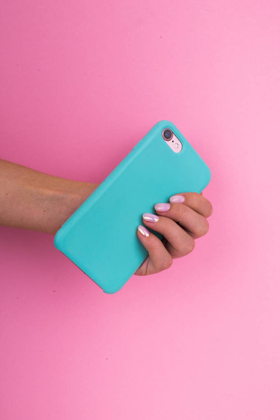 Smartphone in a mint case on a pink background. - Photo, Image