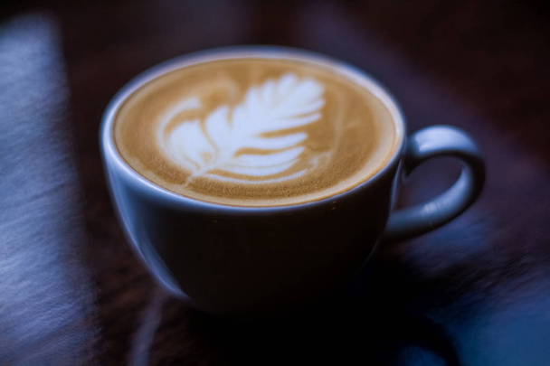 Cappuccino em copo de padrão de roseta branca. Arte latte. Fundo escuro. Café da manhã
. - Foto, Imagem
