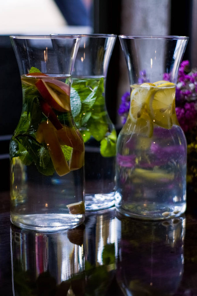 Useful and beautiful water with mint and fruit in glass pitcher. Glasses. Detox. Natural lemonade. - Φωτογραφία, εικόνα
