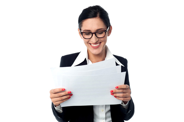 Manager smilingly looking at business reports - Foto, imagen
