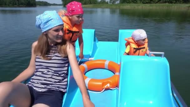 Junge Mutter mit Kindern Junge und Mädchen haben Spaß im Katamaran-Boot. Gimbale Bewegung - Filmmaterial, Video