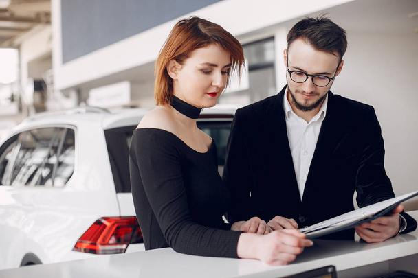 Stylish and elegant couple in a car salon - Foto, afbeelding